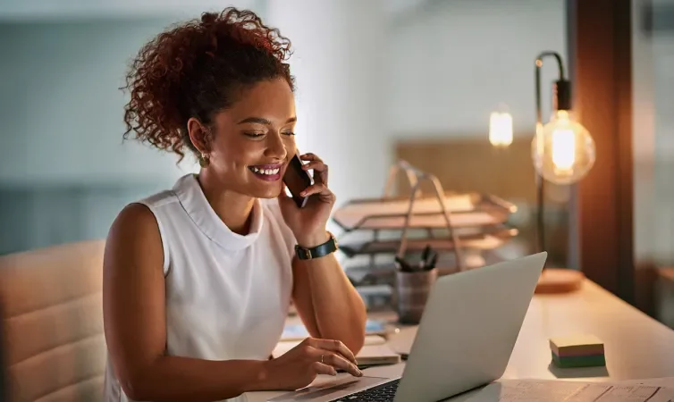 Woman using phone and laptop