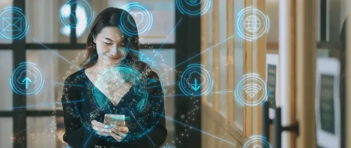 Woman standing with phone surrounded by blue digital icons