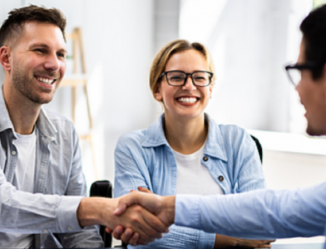 men shaking hands across table